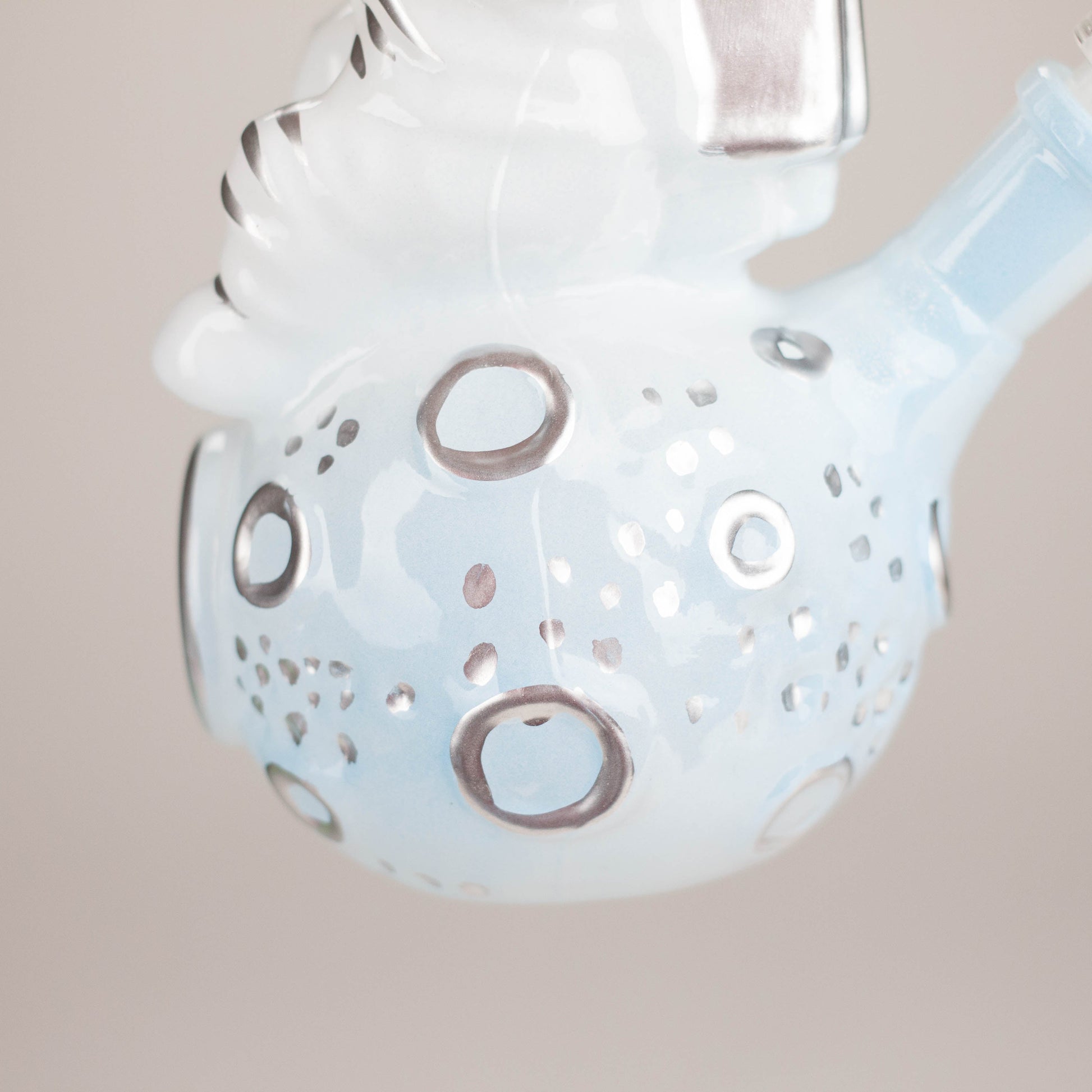 Decorative glass item with circular patterns on a beige background