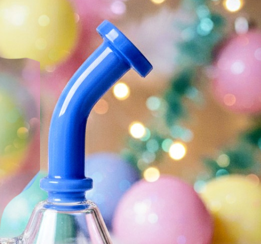 Clear bottle with blue straw-like nozzle against a colorful blurred background